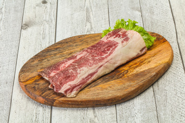 Raw beef bacon over wooden board