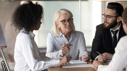 Motivated multiracial colleagues discuss ideas at meeting