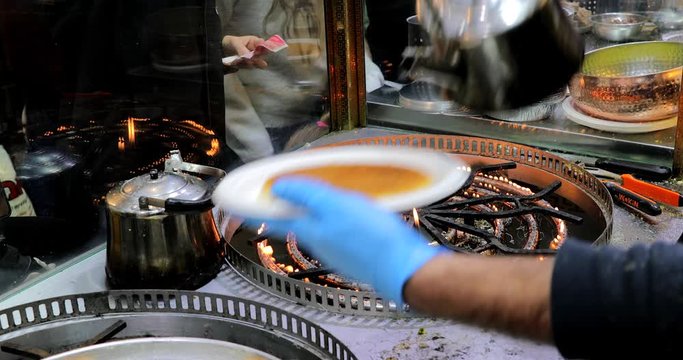 Chef at an oriental food stall in the market making Middle-Eastern Delicious traditional dessert kadayif kunefe with pistachios. Turkish dessert kadayif kunefe.