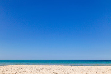 Fototapeta na wymiar Beautiful peaceful sea water splashing at sandy seashore. Clear blue sky over sea water. Tunisia landscape. Horizontal color photography.
