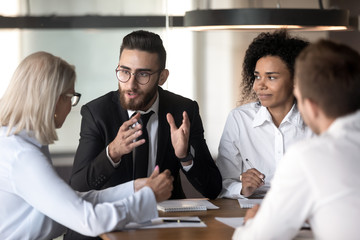 Diverse businesspeople discuss business ideas at team meeting