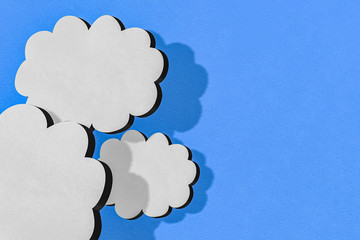 White clouds on blue sky with paper cut effect. Perspective 3D view illustration background with copy space and shadows. Creative design banner