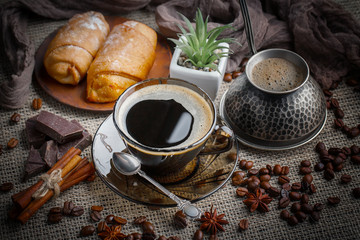Coffee in a cup and saucer on an old background.