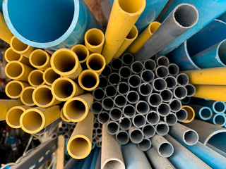 Yellow plastic pipe and blue plastic pipe stacked in store