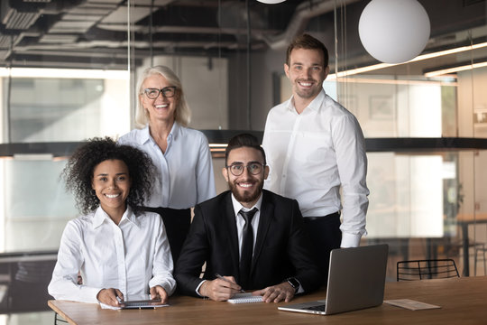 Portrait of smiling multiracial colleagues posing for picture in office