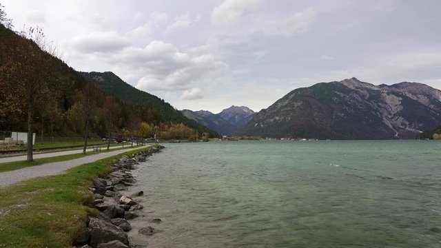 Achensee (achen lake) in the mountains of austria in the alps with the historic steam train and tracks running along the shore. Tirol in Autumn