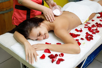 Obraz na płótnie Canvas Masseur applying cream to woman's back. Massage in spa salon