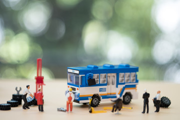 Miniature people: Workers fixing Thai public bus. Maintenance concept.