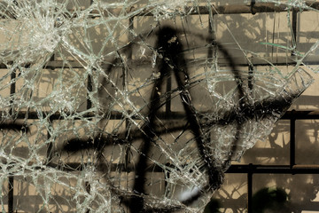 Anarchy symbol painted on cracked glass of a broken shopping window