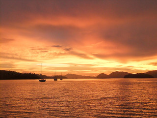 Fototapeta na wymiar Sunrise with Sailboat in silhouette