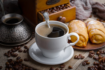 Coffee in a cup and saucer on an old background.