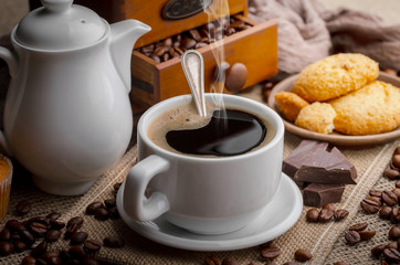 Coffee beans are roasted in a pan with smoke.