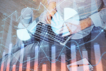 Forex graph with businessman working on computer in office on background. Concept of analysis. Double exposure.