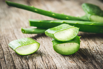 Fresh sliced aloe vera on rich grain wood table.