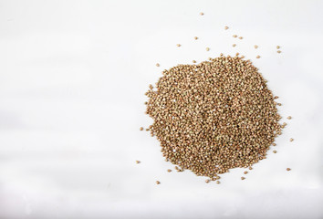 raw green buckwheat scattered on a white background. Close-up. Copy spaes. Horizontally
