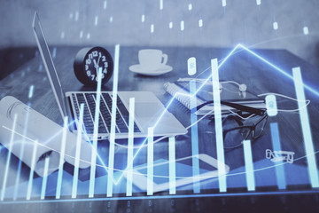 Forex graph hologram on table with computer background. Multi exposure. Concept of financial markets.