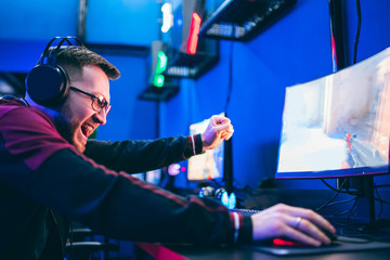 Professional cyber video gamer studio room with personal computer armchair, keyboard for stream in neon color blur background. Soft focus