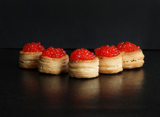 Tartlets with red caviar on the Christmas table, with decorations in the form of a Christmas tree. Christmas and new year snack. Christmas celebration. Selective focus.