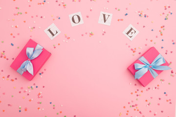Valentines day composition with love inscription and gifts on pink background. Flat lay