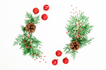 Naklejka na ściany i meble Christmas frame of pine branches and red balls decoration with candy cane on white background. Flat lay