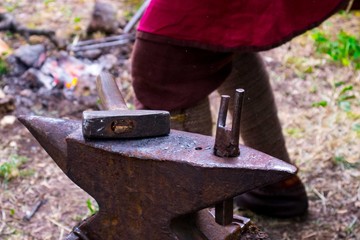 the work on the anvil, vintage blacksmith hammer and tongs