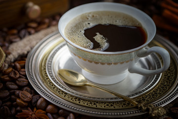 Coffee in a cup and saucer on an old background.