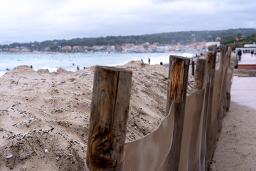 Plage de sable de Saint-Cyr-Sur-Mer en hiver avec surfeurs et récupération du sable