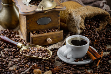 Coffee in a cup on a background of coffee beans, on an old background.