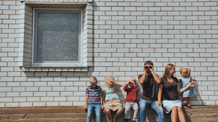 Obraz premium A large family with four children in front of their own home.
