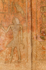 Ancient egyptian paintings and hieroglyphs carved on the stone wall