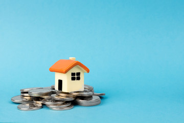 house and mountain of coins on a blue background