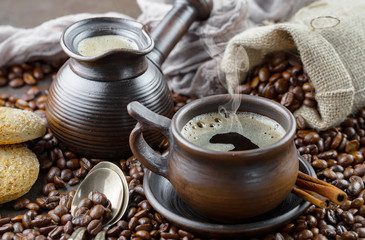 Black coffee beans roast in a pan in the smoke