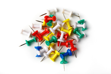 Push pins of different colors lie on a white surface