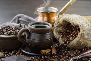 Black coffee beans roast in a pan in the smoke