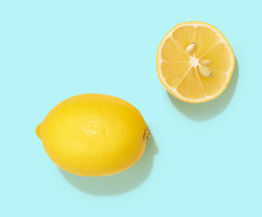 Fresh lemon and lemon half isolated on bright blue background