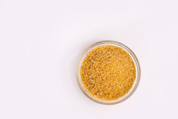 Wheat groats in a plate on a white background. Groats in a small plate. Healthy breakfast on a white background.