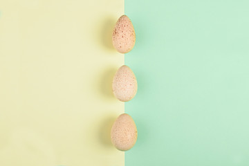 Three turkey egg on colored paper background. Food concept in minimal style. Top view. Alternative decoration.
