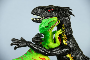 two plastic dinosaurs hugging each other