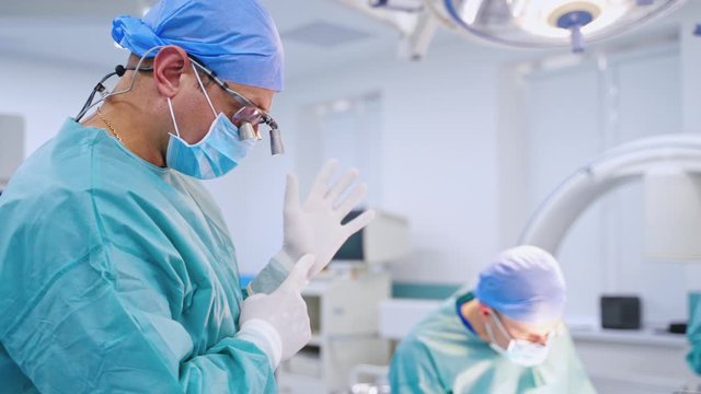 Doctors in medical uniform. Male surgeon talks to someone in the operating room. Professional doctor on the background of a modern medical room.