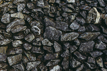 Stone in concrete wall for background. in dark tone.