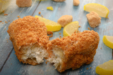 One broken cake, pieces of brown sugar and marmalade lemon slices on a wooden background.