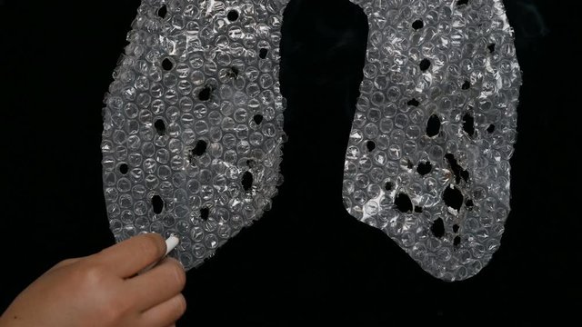 cigarette impaling lung shape bubble wrapping concept of the danger of smoking