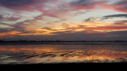 Fototapeta na wymiar Sonnenuntergang am Meer im Watt mit orangen Farben
