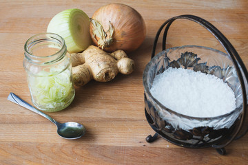 Homemade onion syrup with ginger on wooden background
