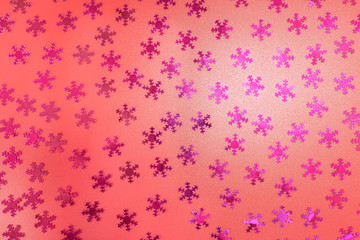 Glittering purple stars arranged randomly, lying flat on a red background.