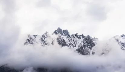 Muurstickers Panoramic snow mountain with white cloudy sky © SasinParaksa