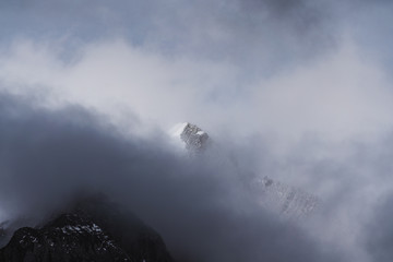 Snow mountain peak behind dark cloudy 