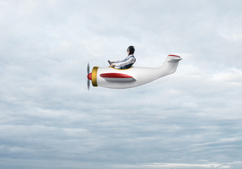 Man in aviator hat driving propeller plane