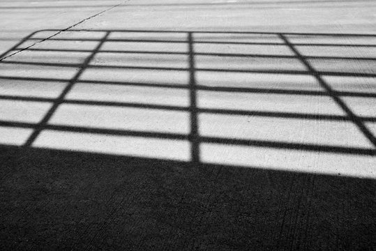 The shadow of car grille apper on the street.