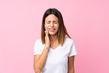 Young woman over isolated pink background with toothache